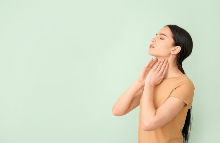 Young woman with thyroid gland problem on color background